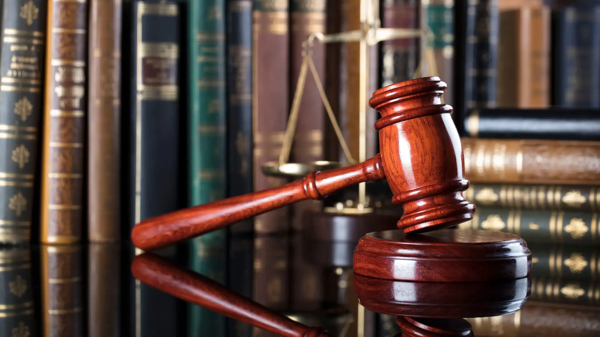 Judge’s gavel and scales of justice in front of law books